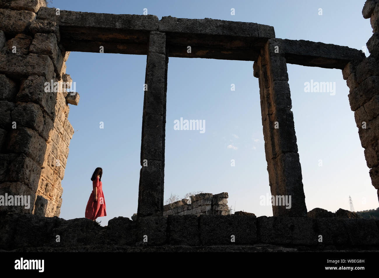 a girl among the columns of the ancient city of Perge Stock Photo