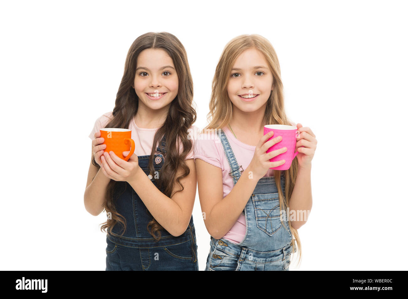 Drinking milk for good health. Cute kids taking a drink of tea with