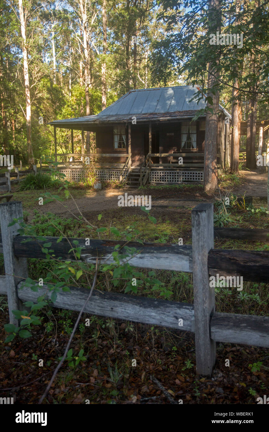 Historic timber settler's cottage  with post and rail fence among tall trees of woodlands at Timbertown tourist complex NSW Australia Stock Photo