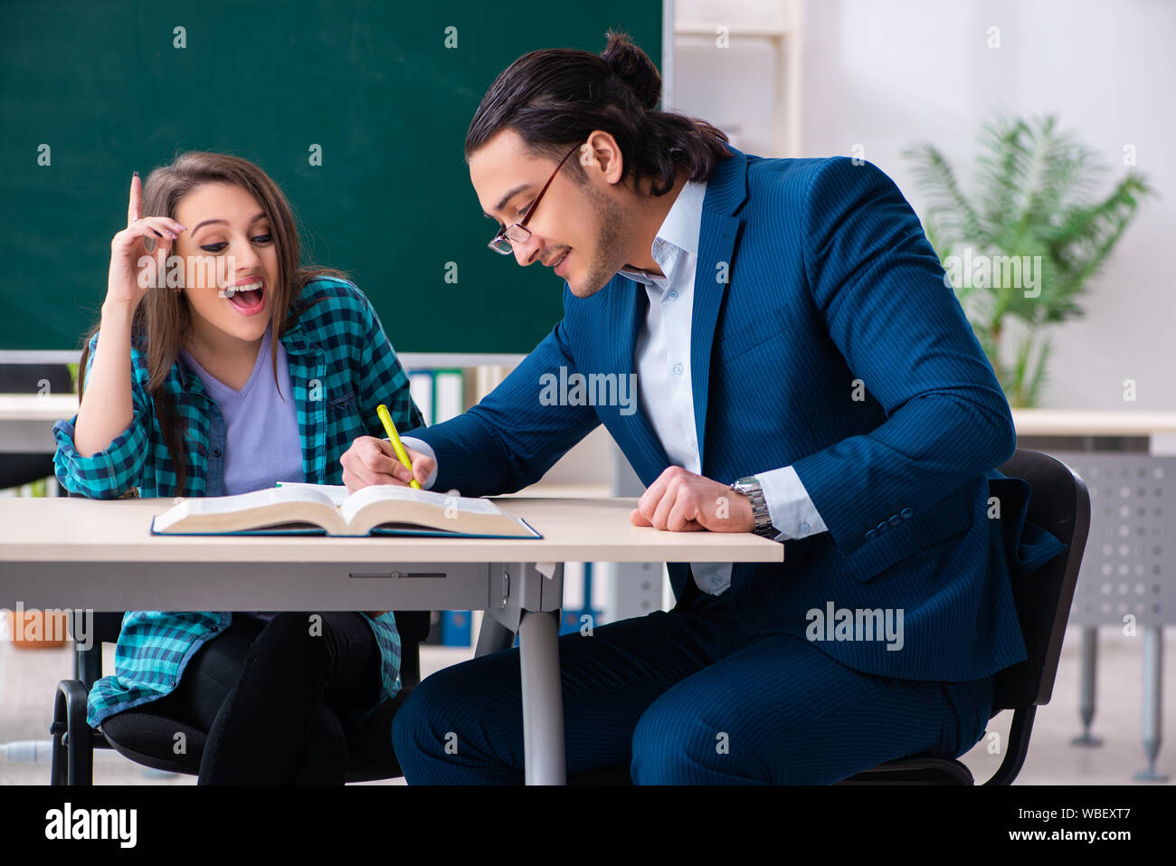 Download this stock image: The young handsome <b>teacher</b> and female student in...