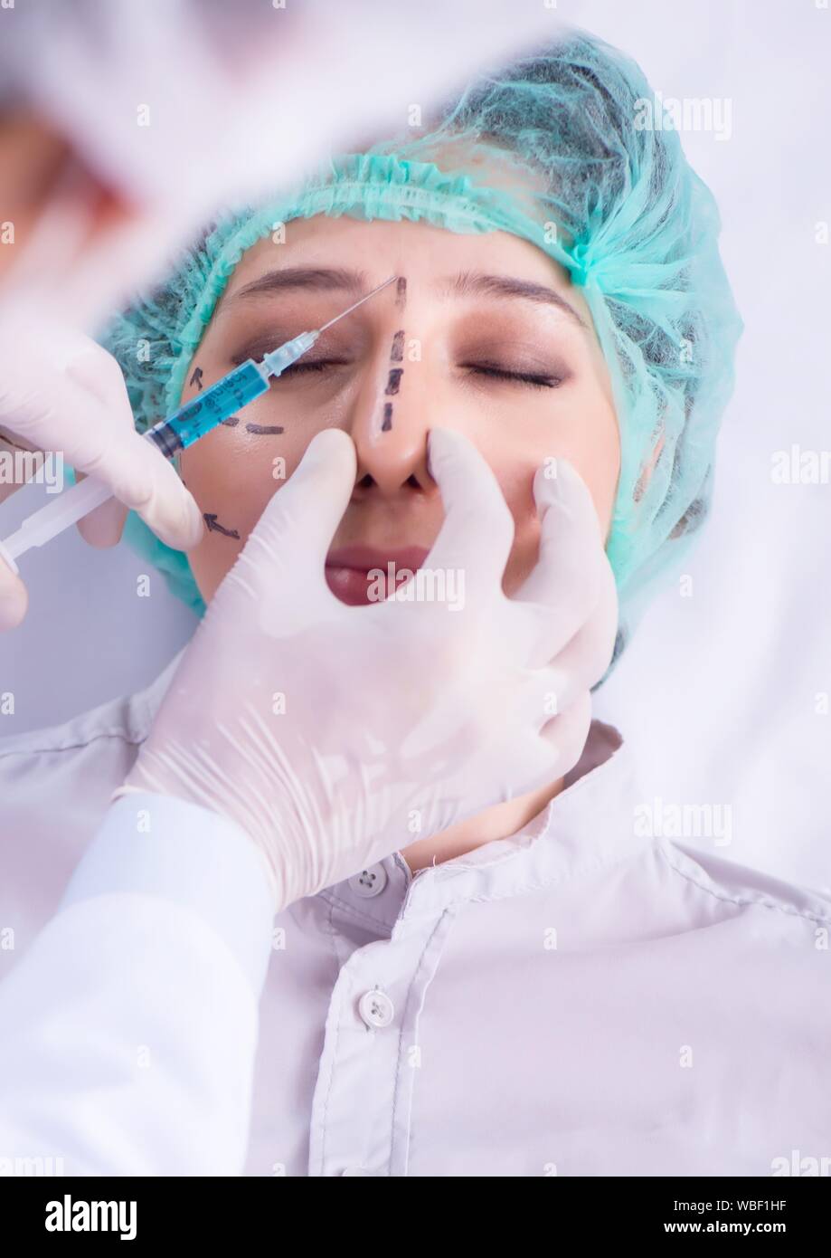 The plastic surgeon preparing for operation on woman face Stock Photo
