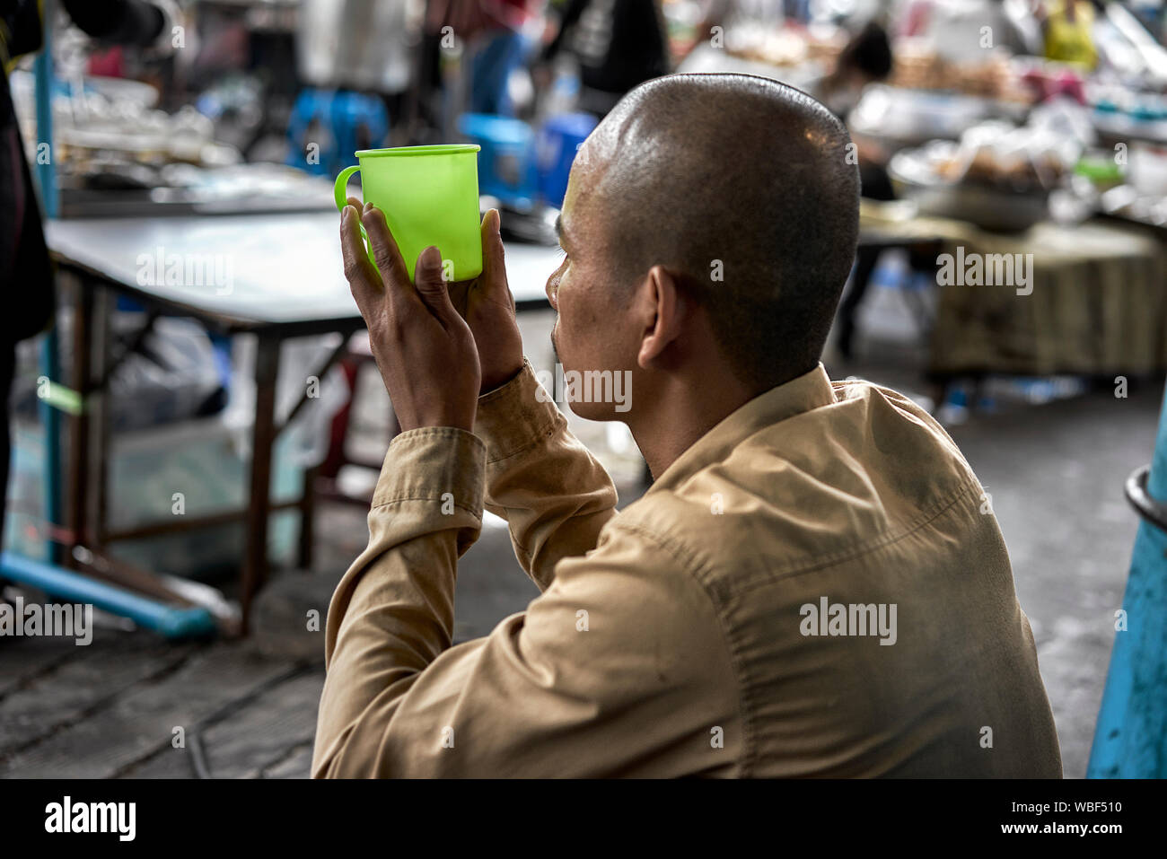 Beggar begging and holding cup for donations. Thailand Southeast Asia Stock Photo