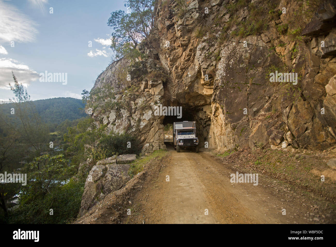 Campervan passing through historic tunnel carved through rocky cliff on old coach road from Glen Innes to Grafton NSW Australia Stock Photo