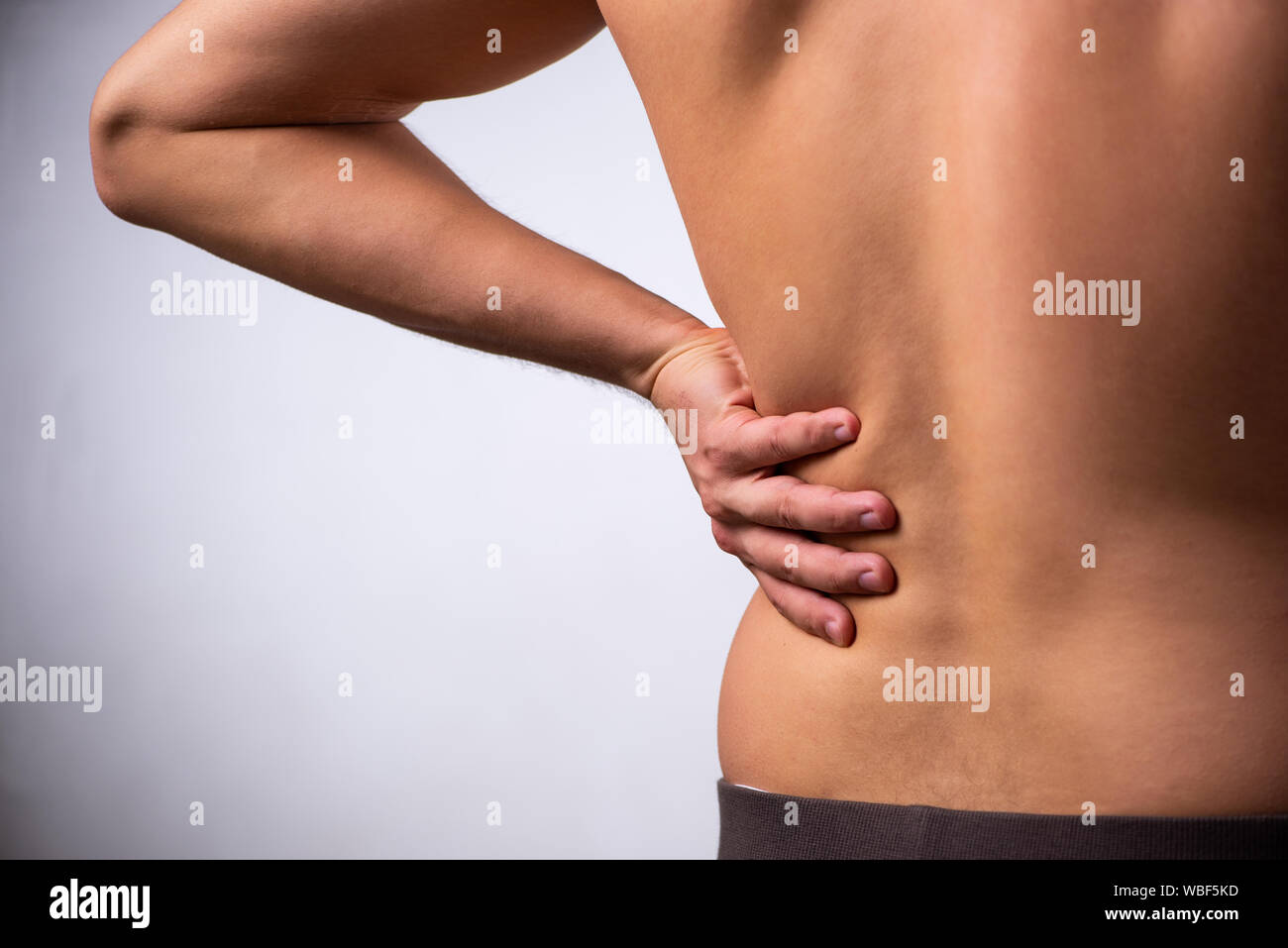 The man suffering from backbain on gray Stock Photo