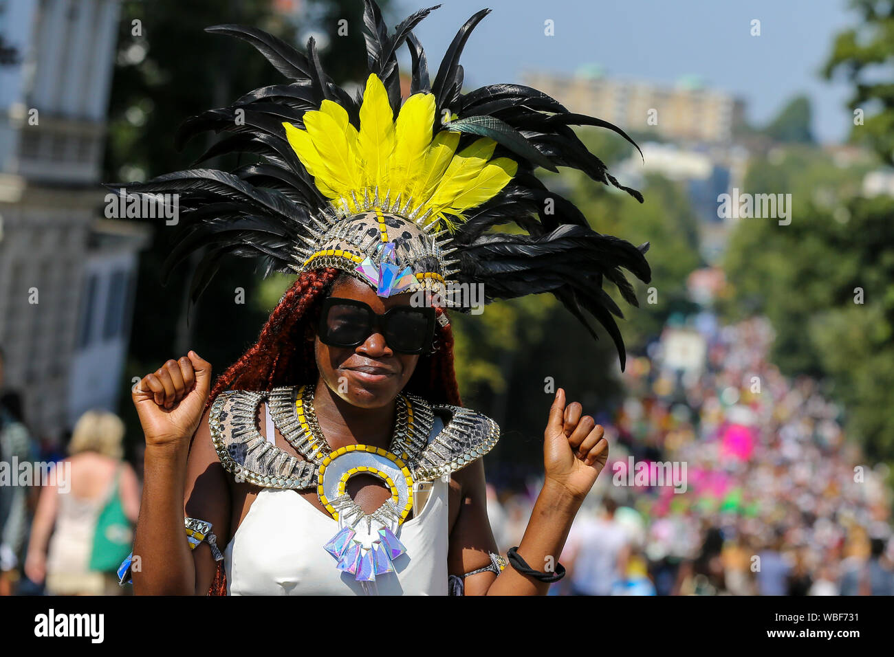 A dancer in a colourful headrest during the 2019 Notting Hill Carnival, Europe's largest street party and a celebration of Caribbean traditions and the capital's cultural diversity. Stock Photo