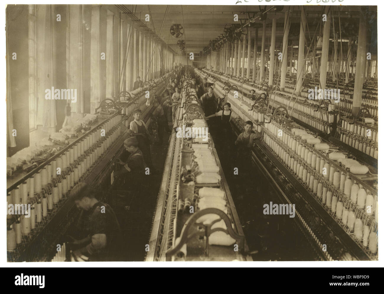 General view of the spinning room, Cornell Mill, showing some of the young boys and girls employed there. Cornell Mill. See names on other photo. Abstract: Photographs from the records of the National Child Labor Committee (U.S.) Stock Photo