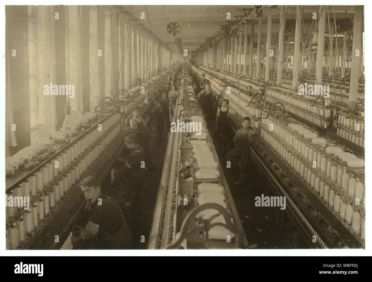 General view of the spinning room, Cornell Mill, showing some of the young boys and girls employed there. See names on other photo. Cornell Mill. Abstract: Photographs from the records of the National Child Labor Committee (U.S.) Stock Photo