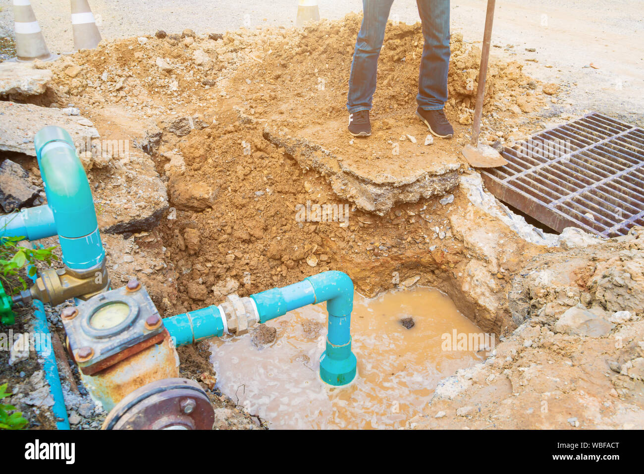 worker repair pipe plumbing water main broken. Use shovel to dig a hole