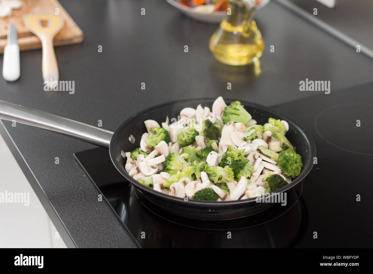 Cooked broccoli and mushrooms in frying pan on stove. Healthy ...