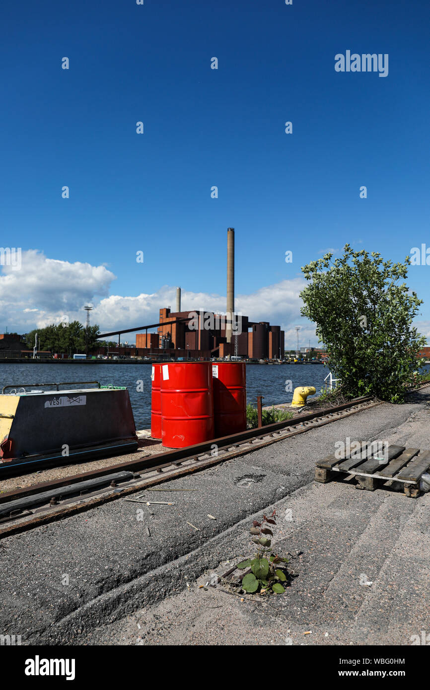 Red oil drums in Sompasaari wasteland, Hanasaari Power Plant in background, in Helsinki, Finland Stock Photo