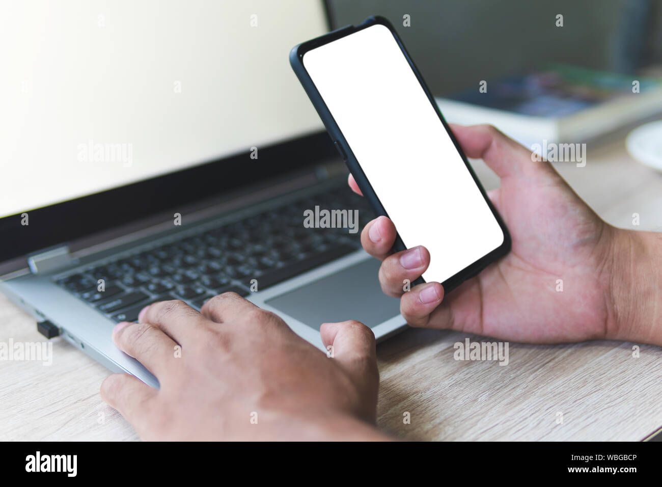 Business man hand holding smart mobile phone, using credit card for online shopping with laptop computer and digital tablet on table. Cyber concept Stock Photo