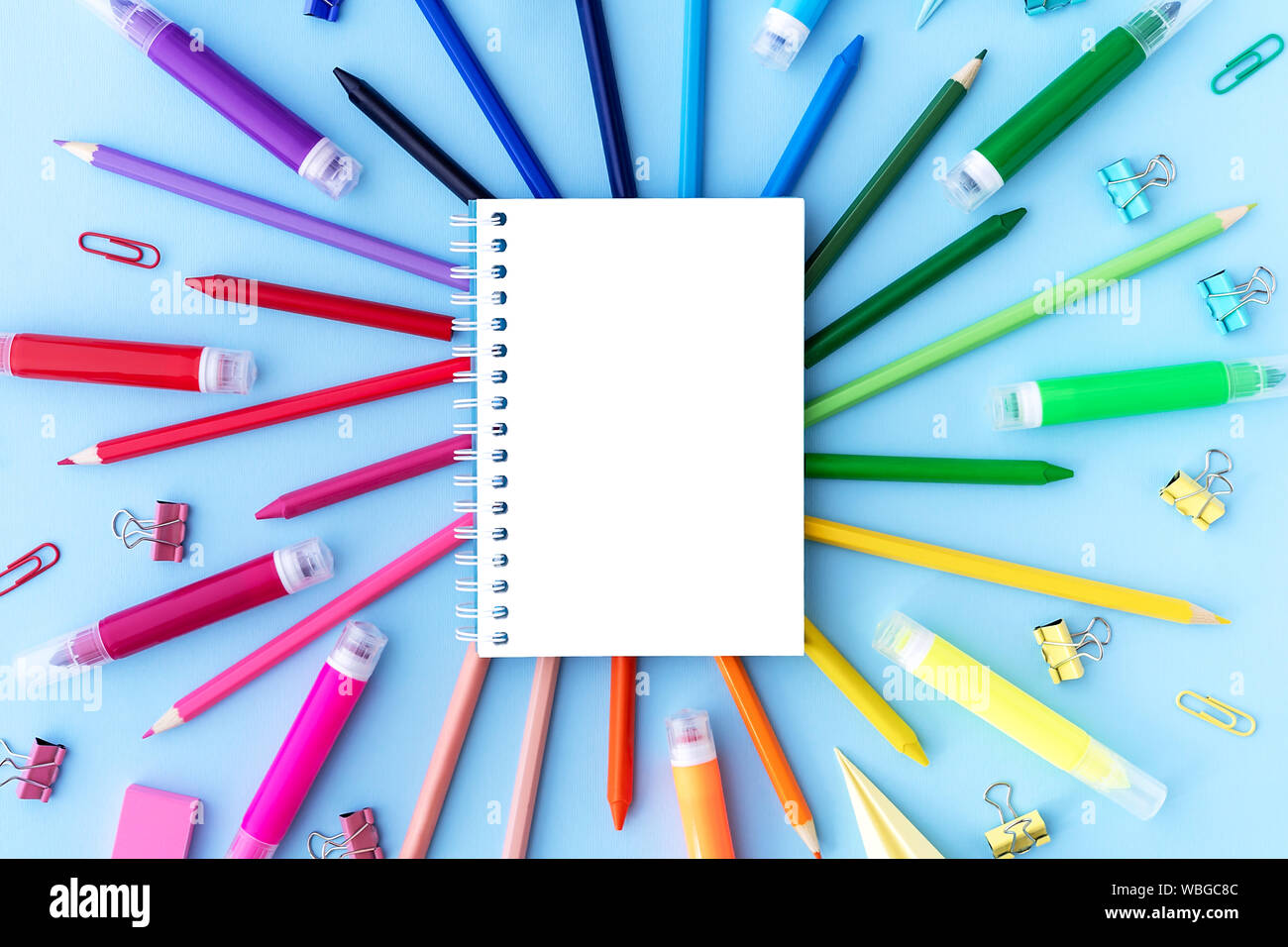 Back to school background with opened notepad and variety of school
