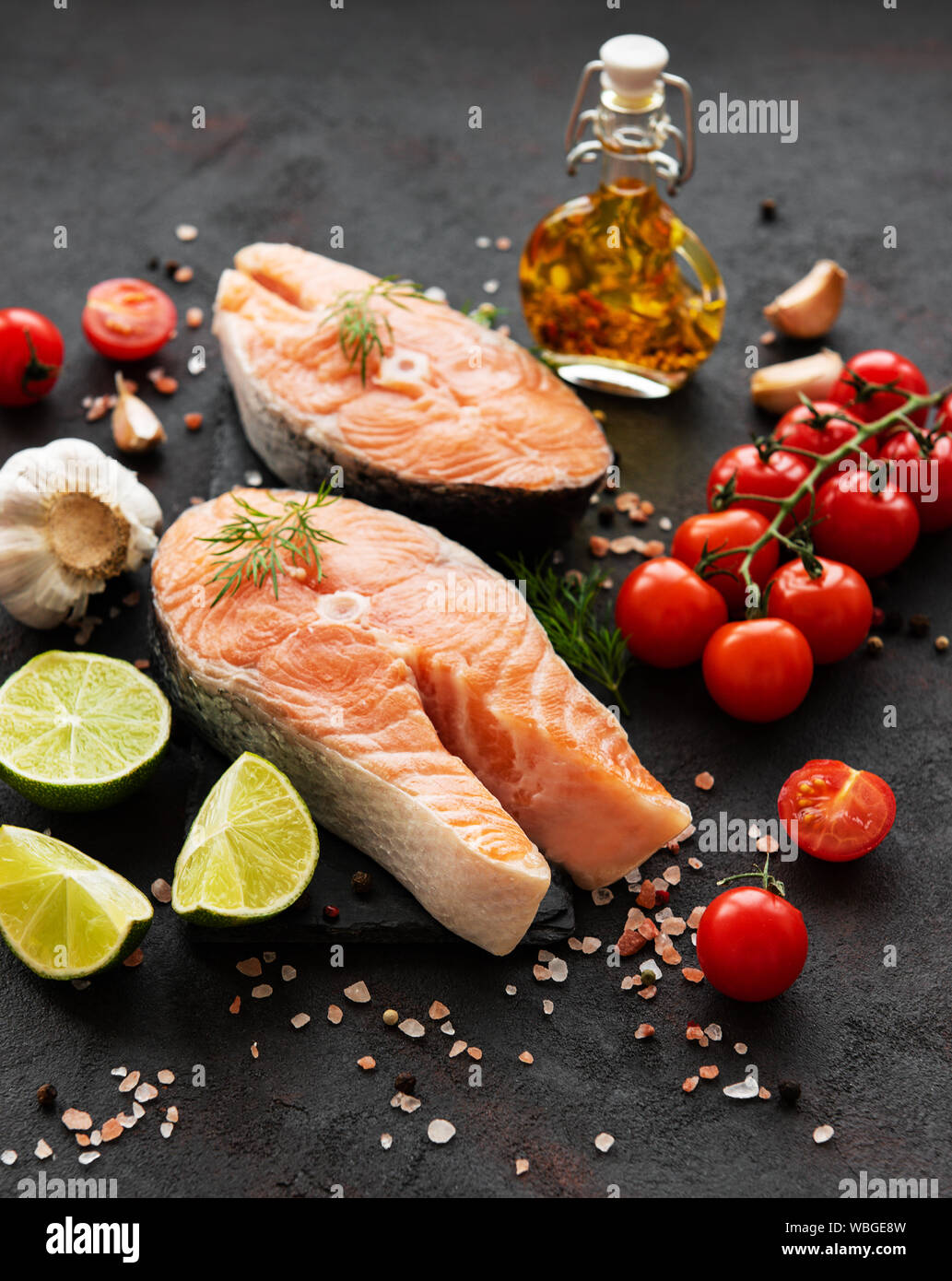 Raw salmon steaks and ingredients on a black slate board Stock Photo ...