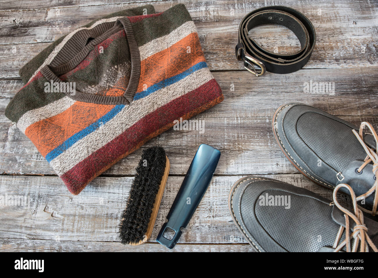 High Angle View Of Striped T-shirt With Shoe And Brush On Table Stock Photo