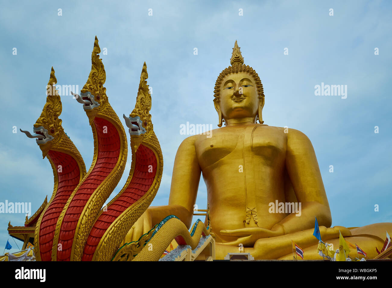 A giant, gold sitting Buddha with snake naga figures at Wat Muang in Ang Thong, Thailand. Stock Photo