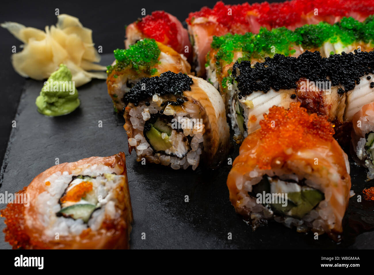Dragon set sushi roll. Red, golden with avocado, salmon and caviar. Stock Photo