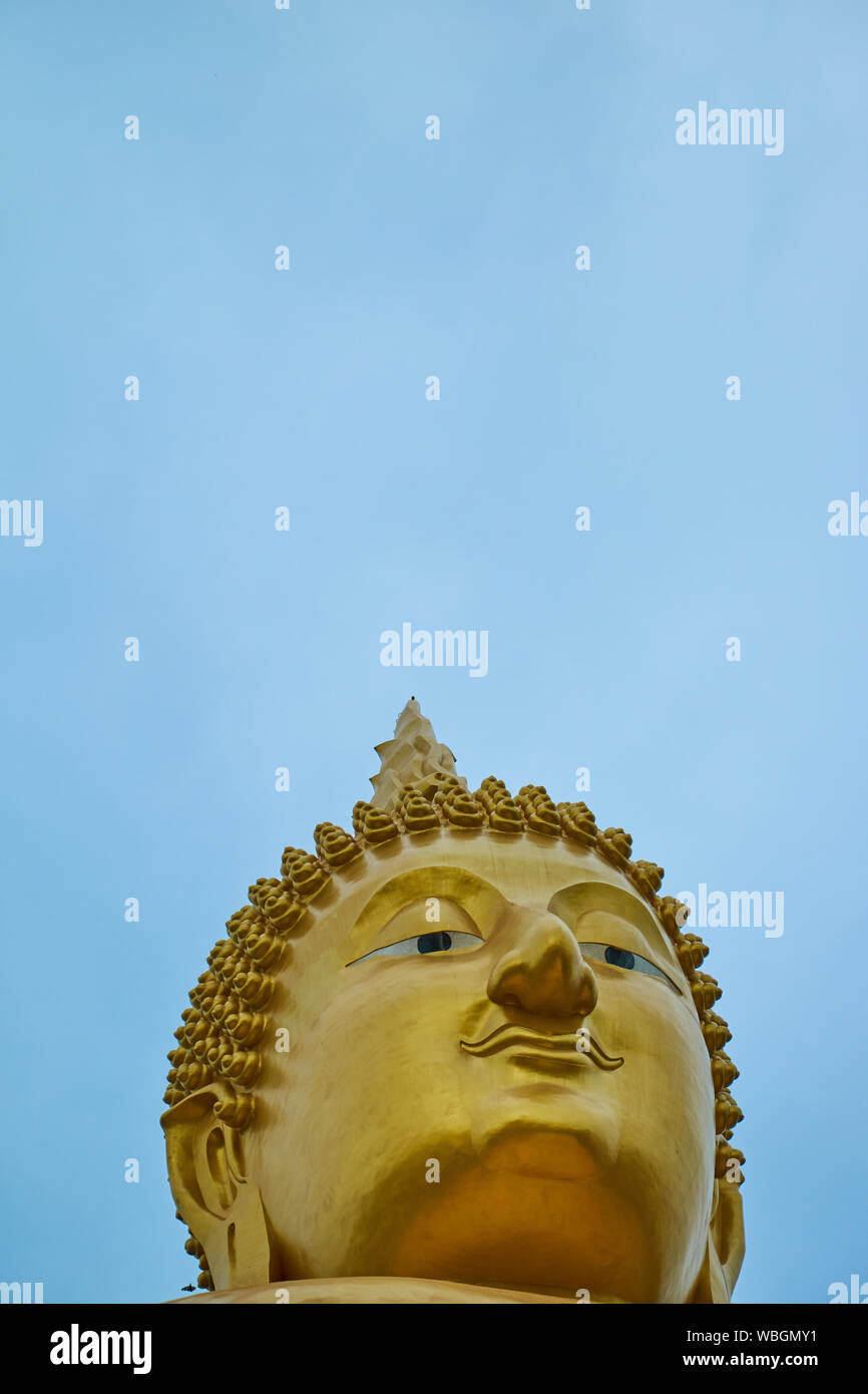 A giant, gold, sitting Buddha at Wat Muang in Ang Thong, Thailand. Empty, negative space for text, information. Stock Photo