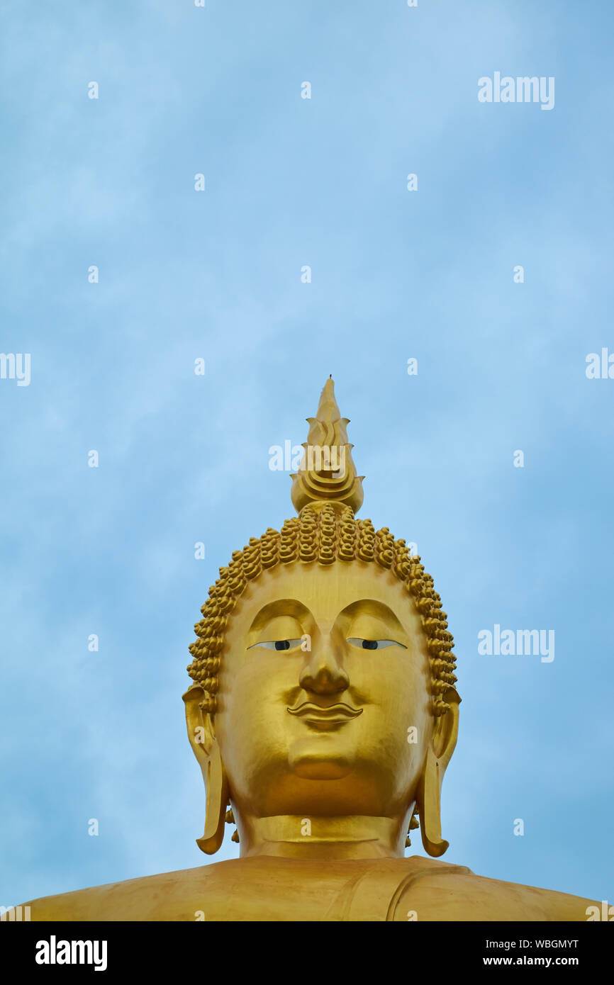 A giant, gold, sitting Buddha at Wat Muang in Ang Thong, Thailand. Empty, negative space for text, information. Stock Photo