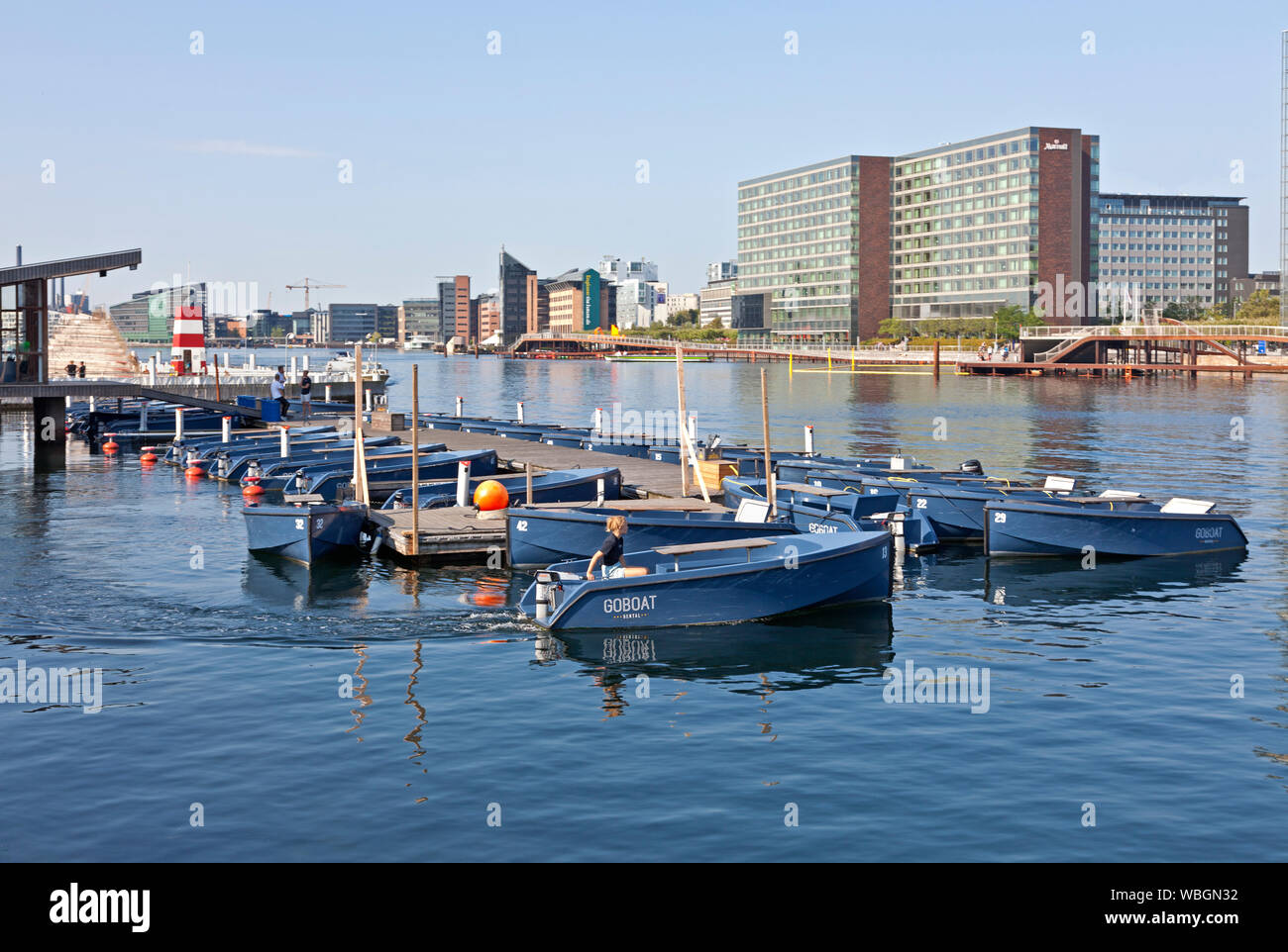 GOBOAT RENTAL, electric tour and picnic boats for hire at Islands Brygge in Copenhagen harbour. Kalvebod Waves opposite side of canal. Summer morning. Stock Photo