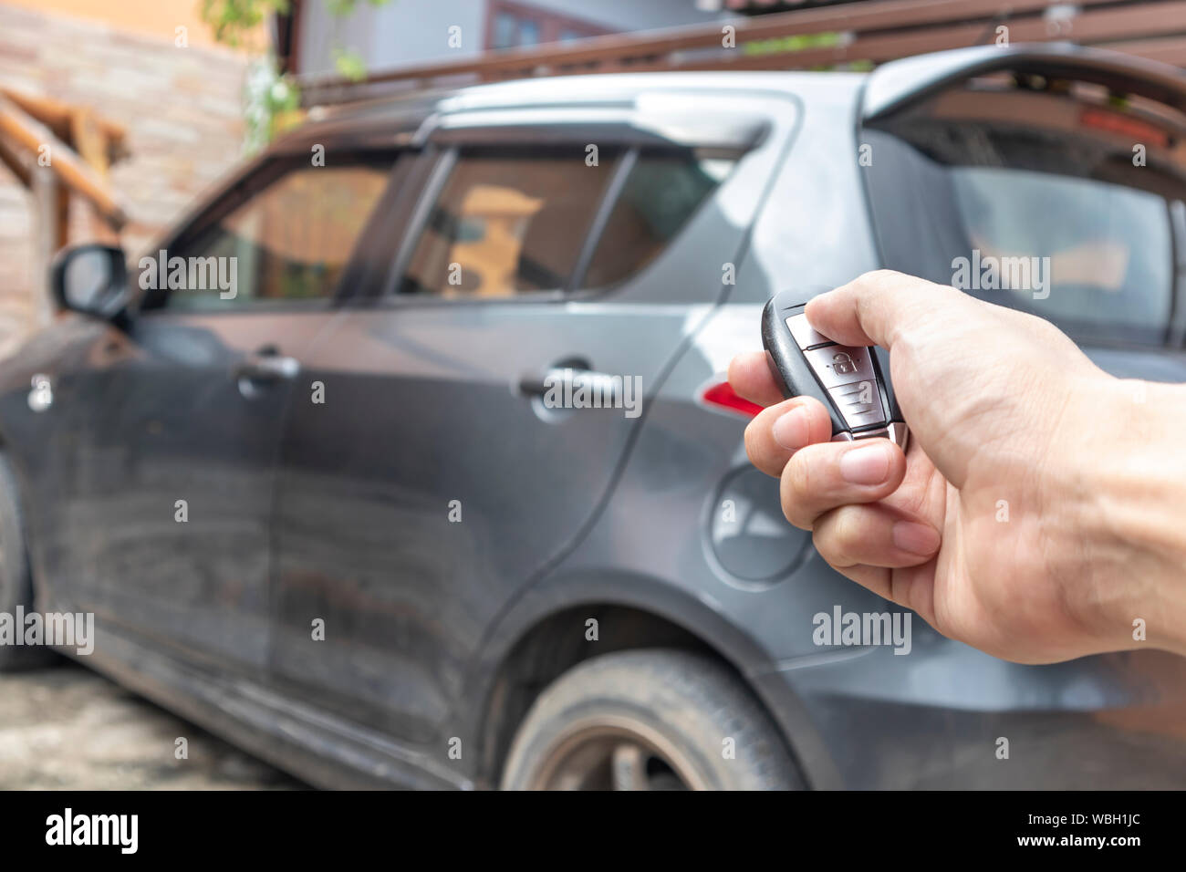 A man opening his car door with pushing button on control remote key