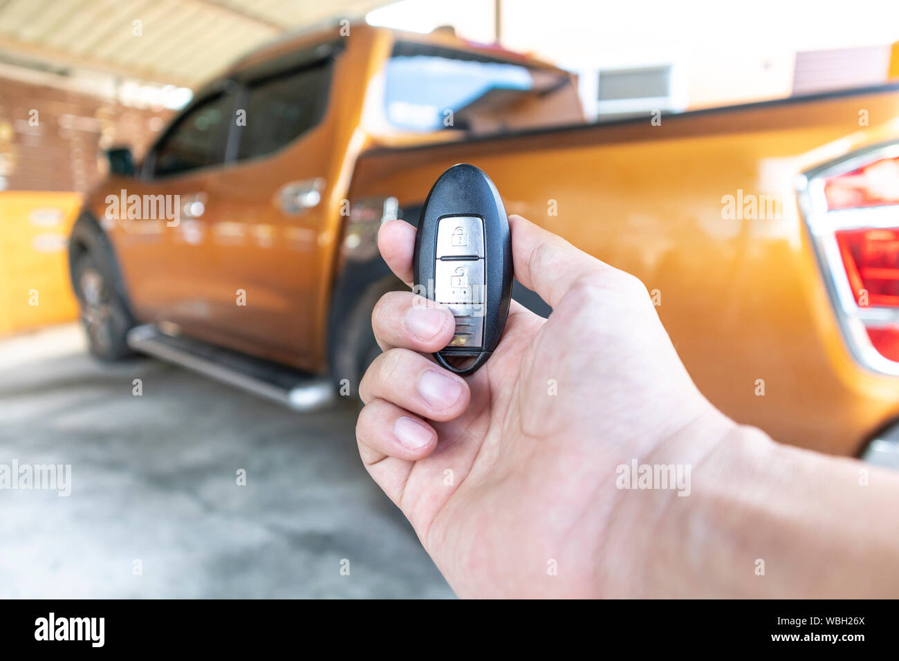 A man opening his car door with pushing button on control remote key ...