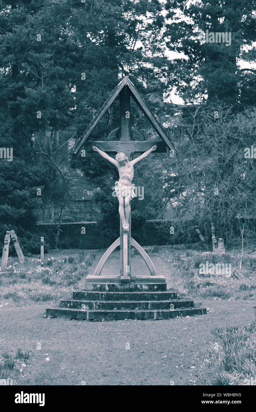 Statue of Jesus Christ nailed to a wooden cross.  With colour toning Stock Photo