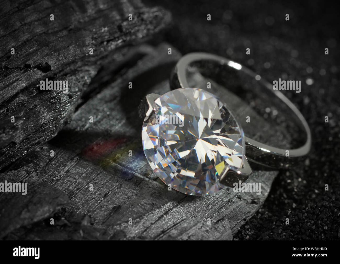 Jewelry ring with big diamond, on black coal texture background Stock Photo