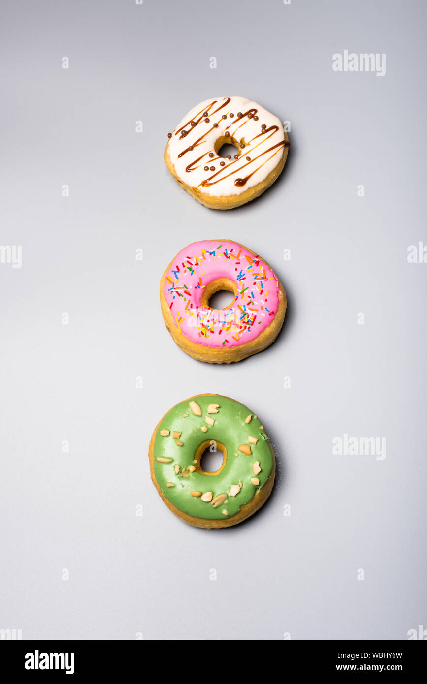 Three fresh sweet bonuts on studio background Stock Photo