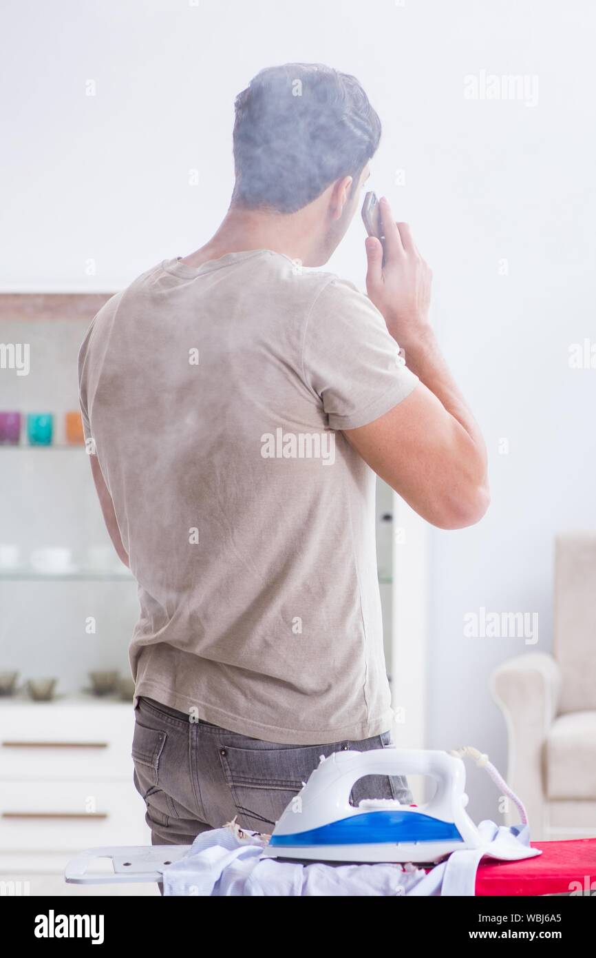 The inattentive husband burning clothing while ironing Stock Photo