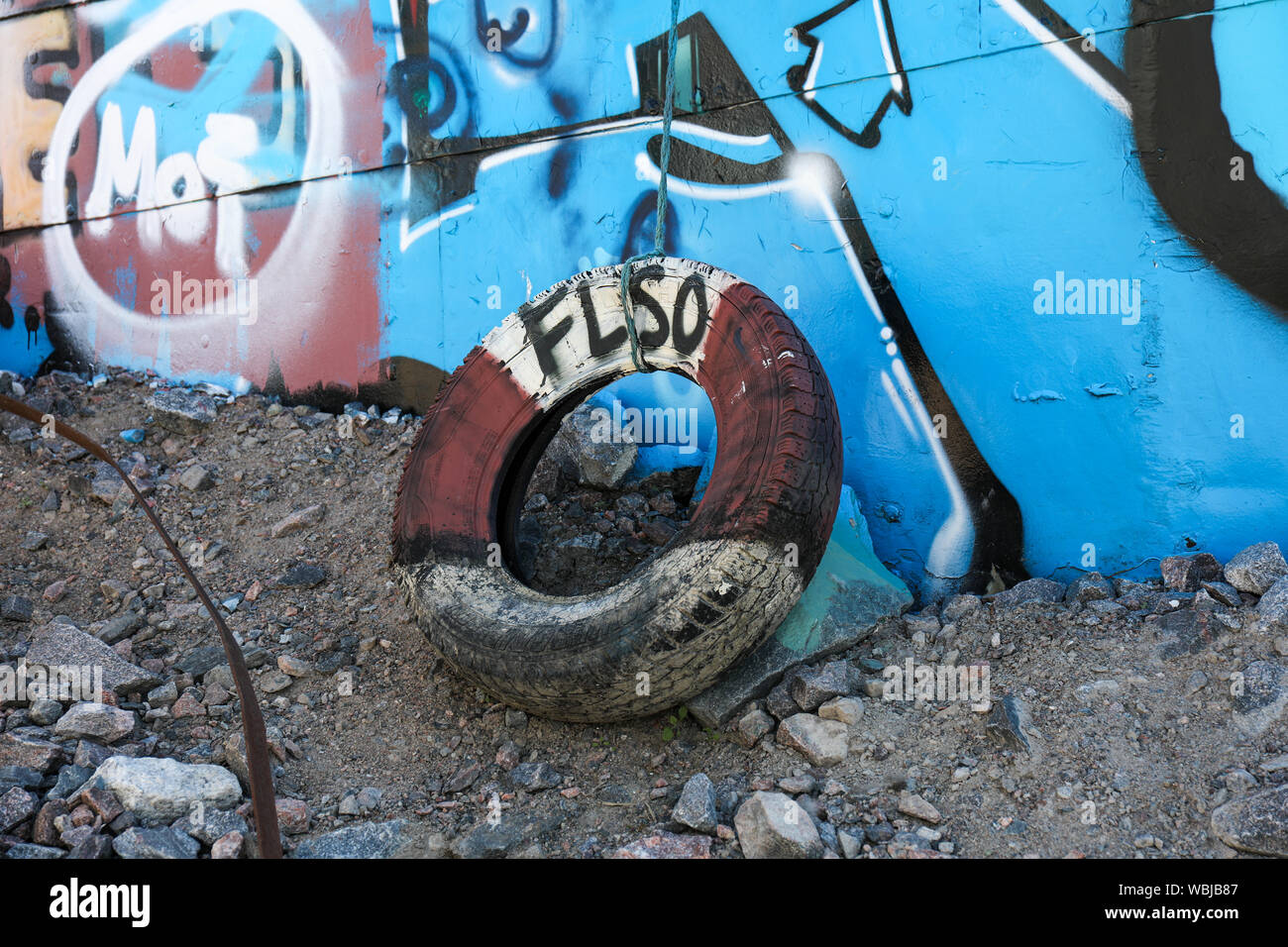 Old tyre fender next to an abandoned and graffiti covered ship on the ground of Sompasaari in Helsinki, Finland Stock Photo