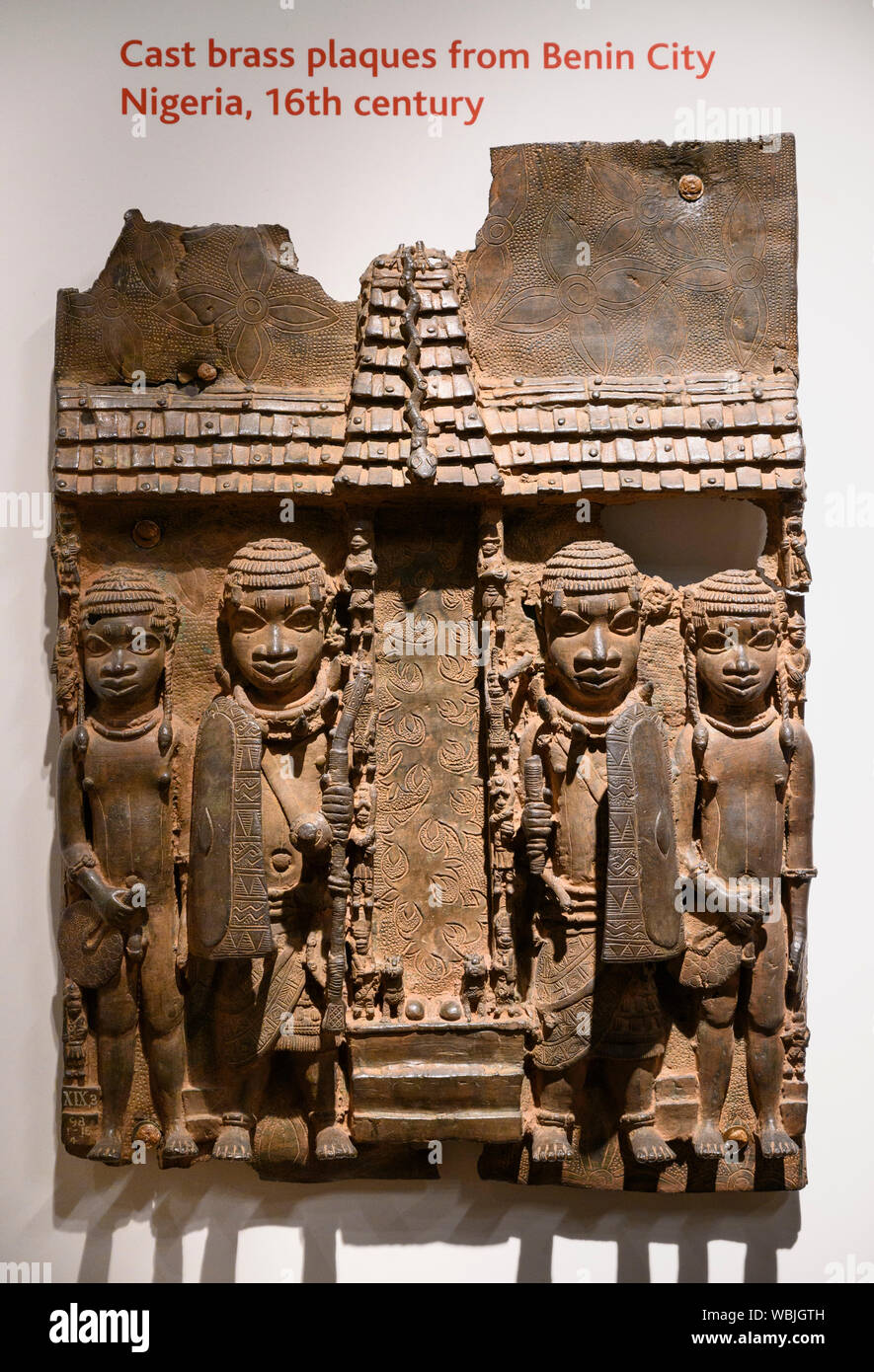 London. England. Benin Bronzes on display at the British Museum, brass plaque showing the facade of the royal palace, 16-17th century. From the royal Stock Photo