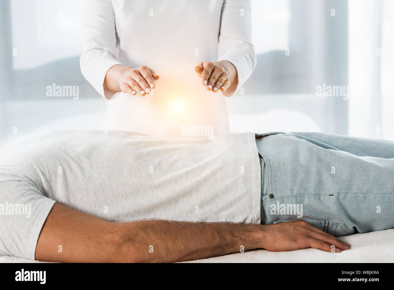 cropped view of woman putting hands above body while healing man Stock Photo