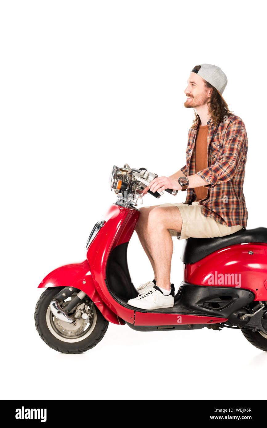 side view of young man sitting on red scooter isolated on white Stock Photo