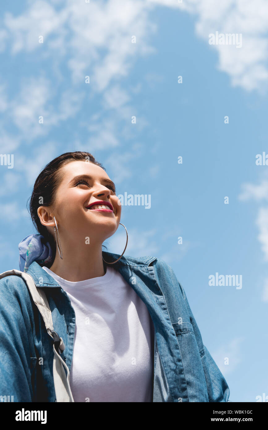 low angle view of beautiful girl looking forward and smiling on sky backgroung Stock Photo