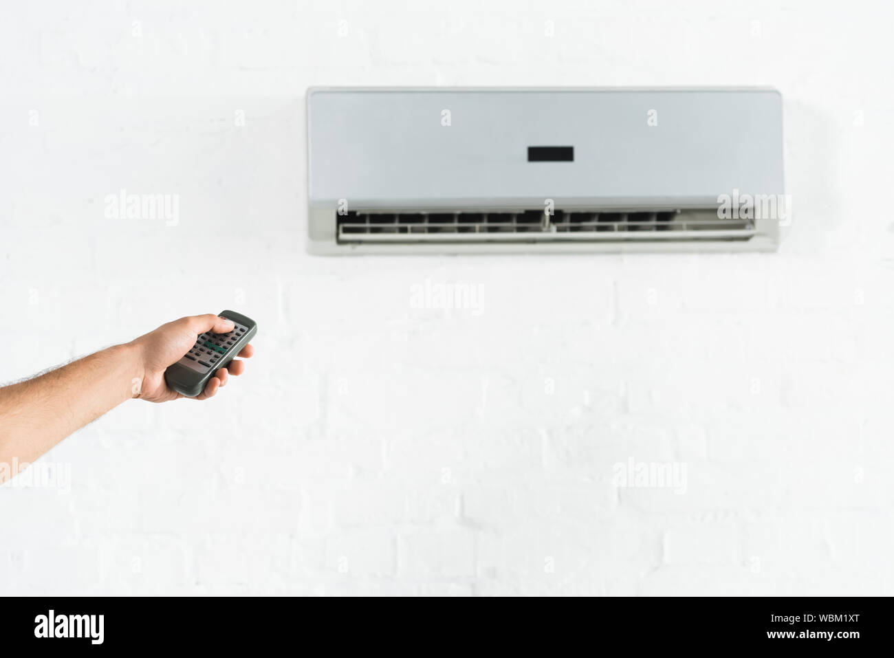 cropped view of man suffering from heat and switching temperature of