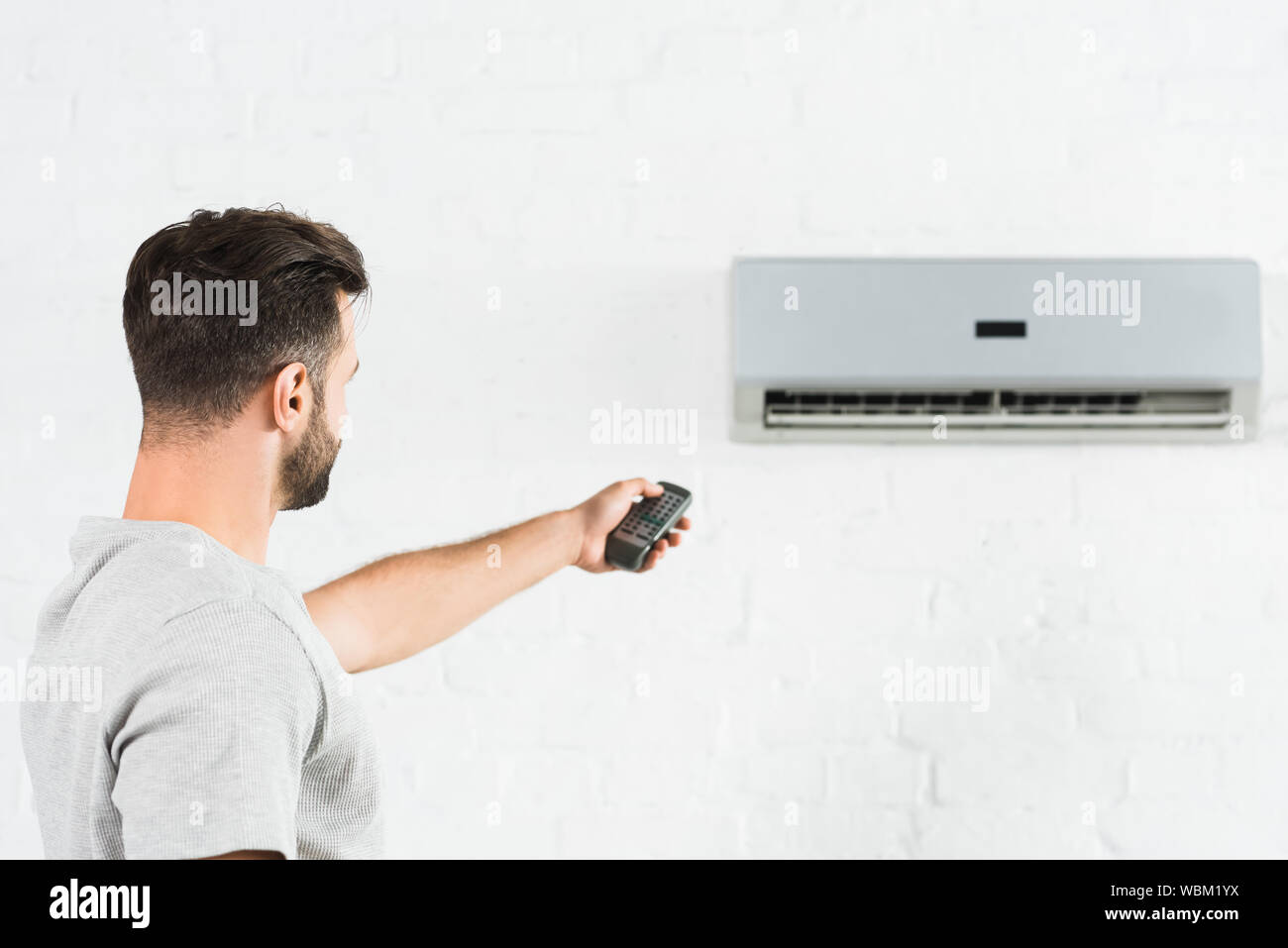 side view of man suffering from heat and switching temperature of air