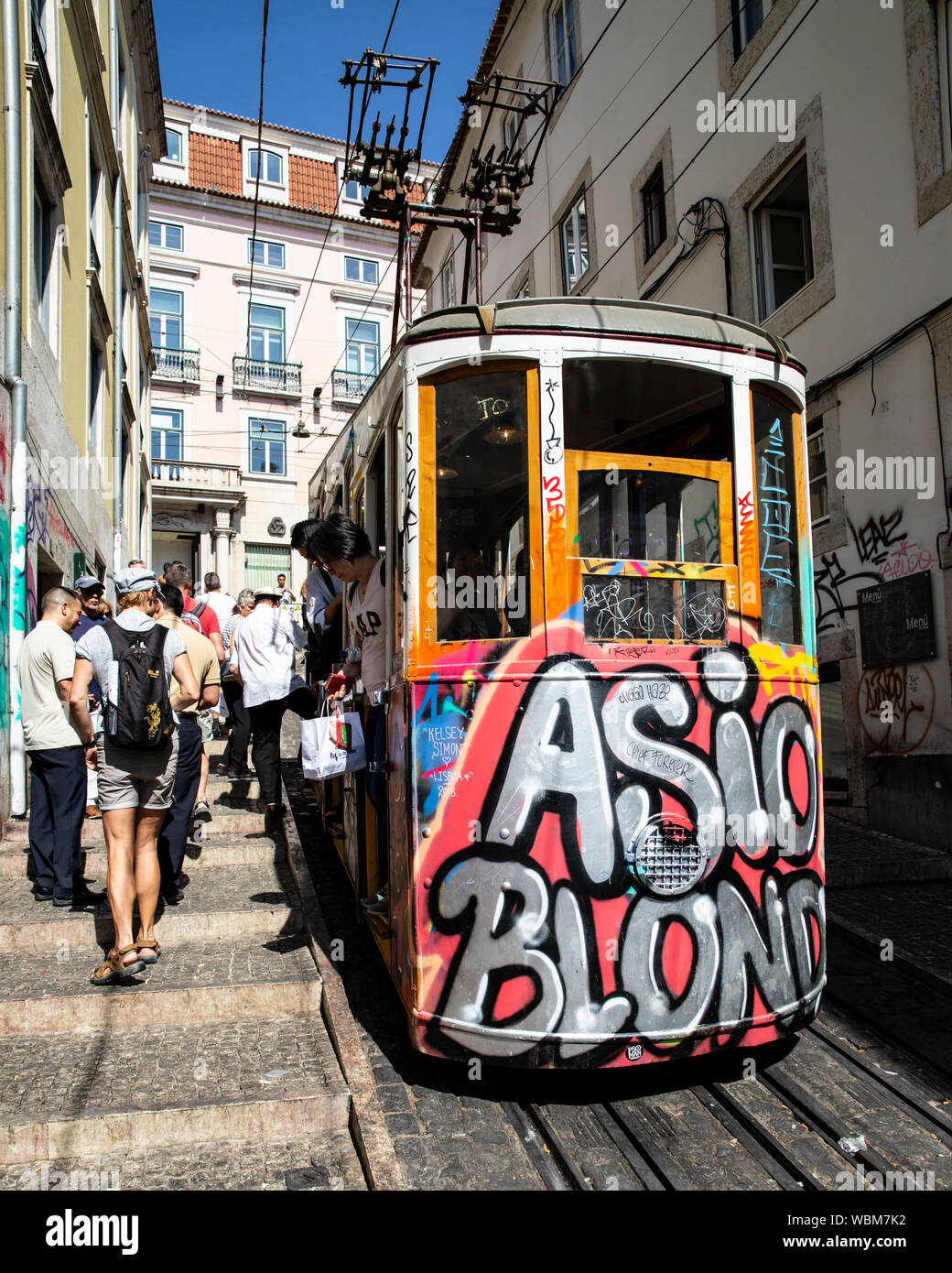Tourists alighting from a graffiti coverd funicular tram, Lisbon, Portugal. Stock Photo