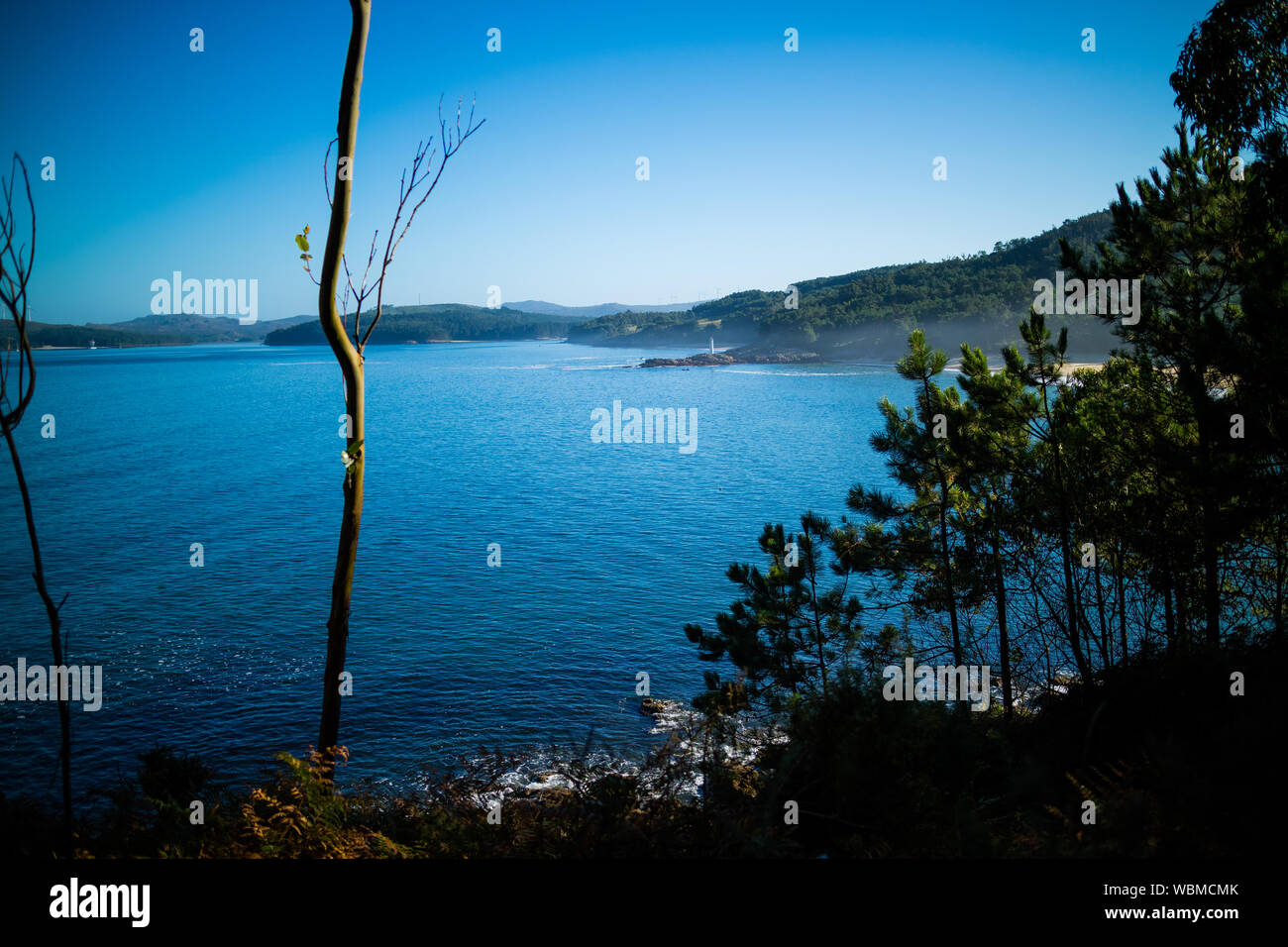 View Of Calm Lake Against Hilly Landscape Stock Photo