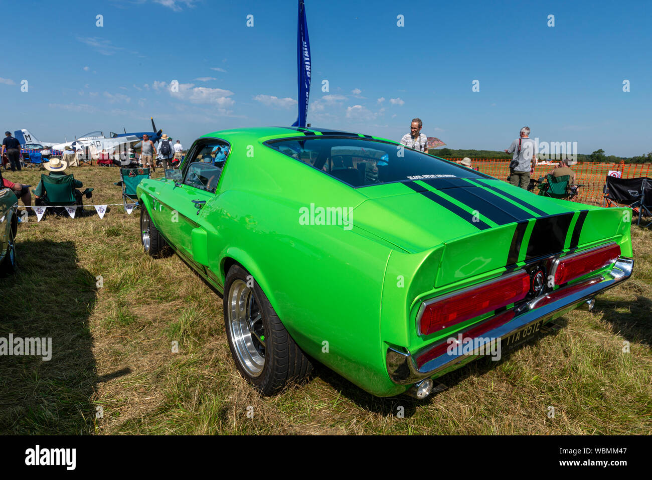 Ford Mustang car at the Children in Need Little Gransden Air and Car Show, with P-51 Mustang plane and people. Shelby Mustang 390gt Stock Photo