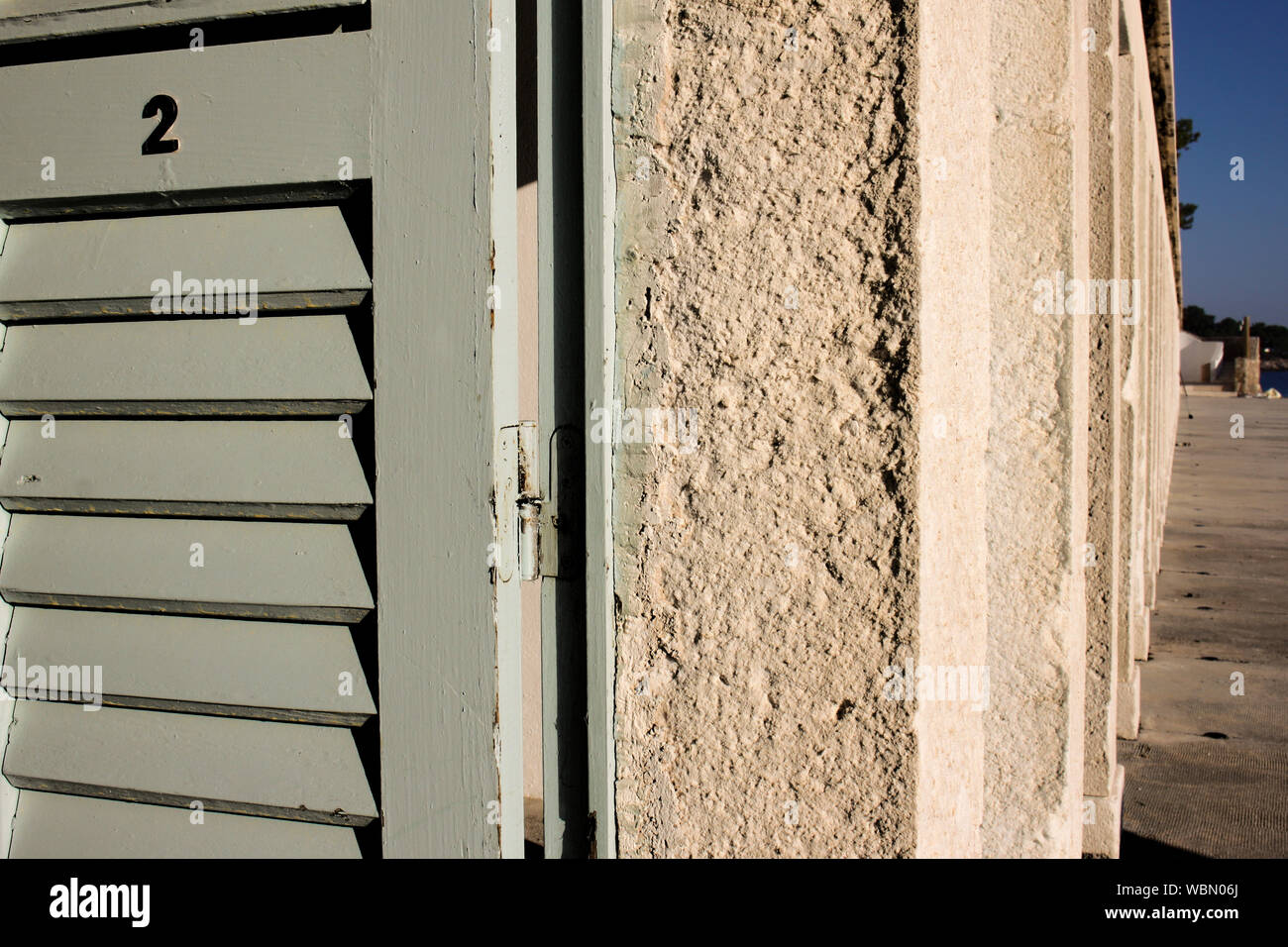 Beach cabins with pastel color doors line up on city beach of Hvar town