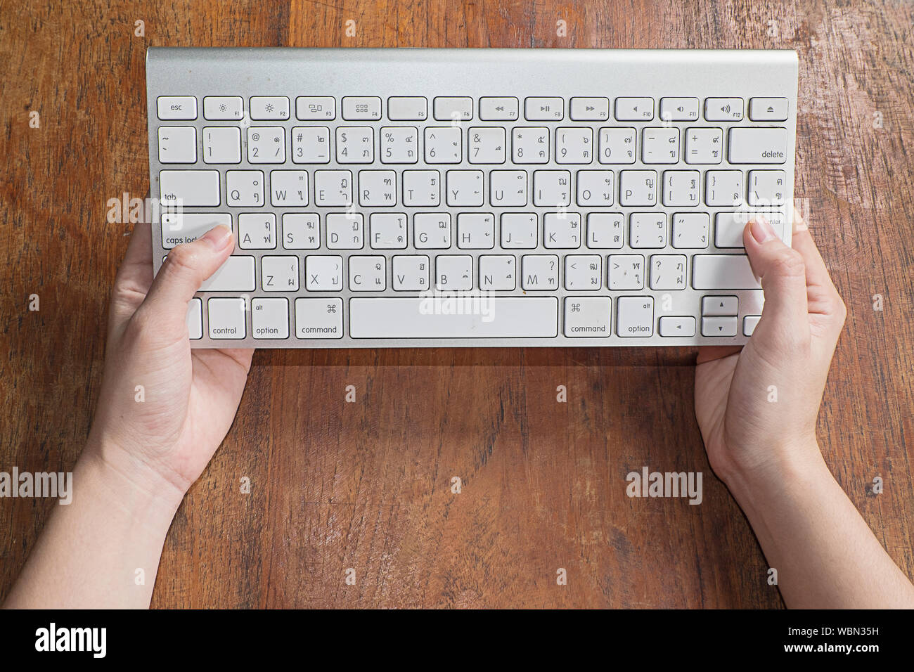 Cropped Image Of Hands Holding Computer Keyboard Stock Photo