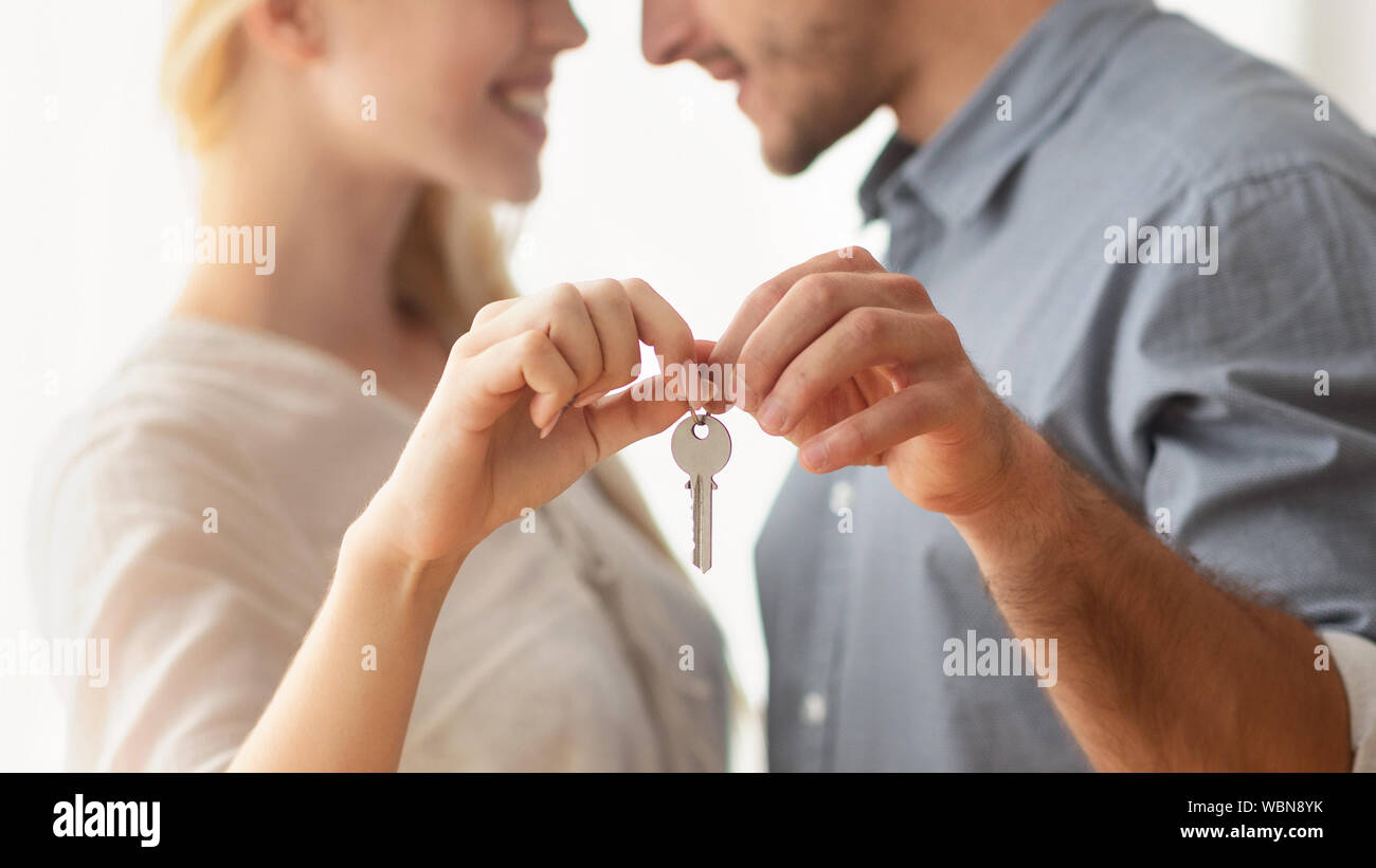 Unrecognizable Man And Woman Hugging Holding New Home Key Indoor Stock Photo