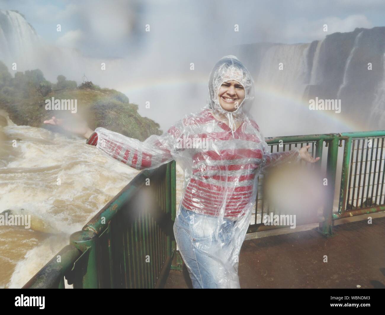 Portrait Of Female Tourist Wearing Raincoat At Iguacu Falls Stock Photo