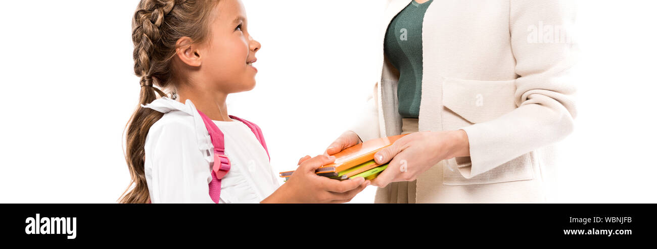 panoramic shot of mother holding books near daughter with backpack isolated on white Stock Photo