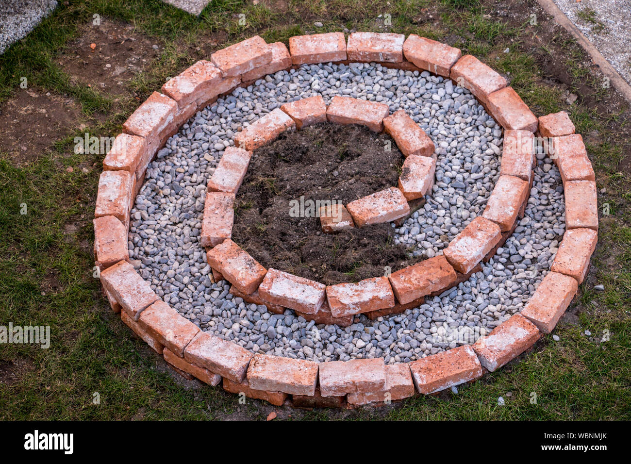 building herbal spiral first layer completed with small pebbles and soil Stock Photo