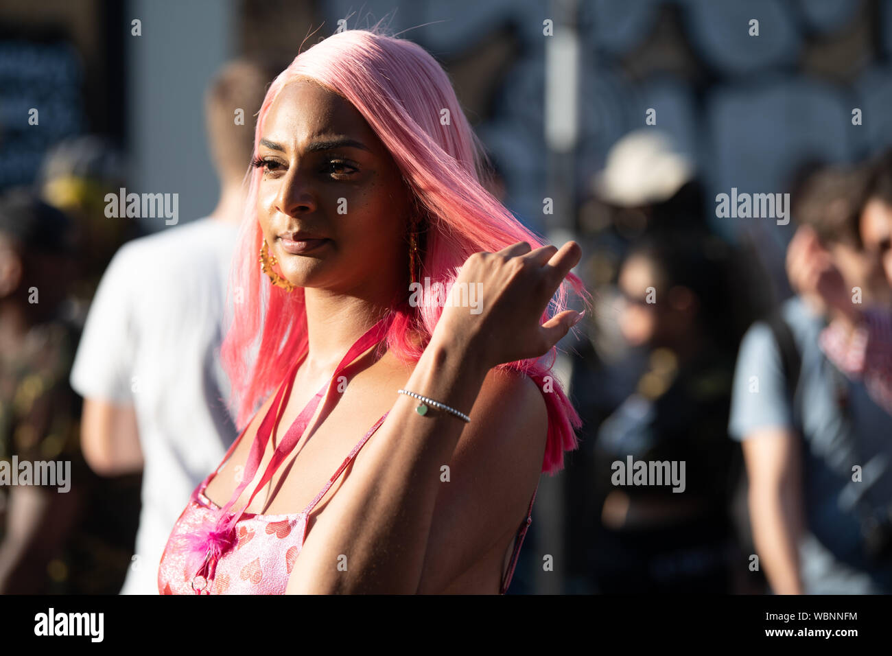 a woman with pink hair attending the Notting Hill Carnival. Stock Photo