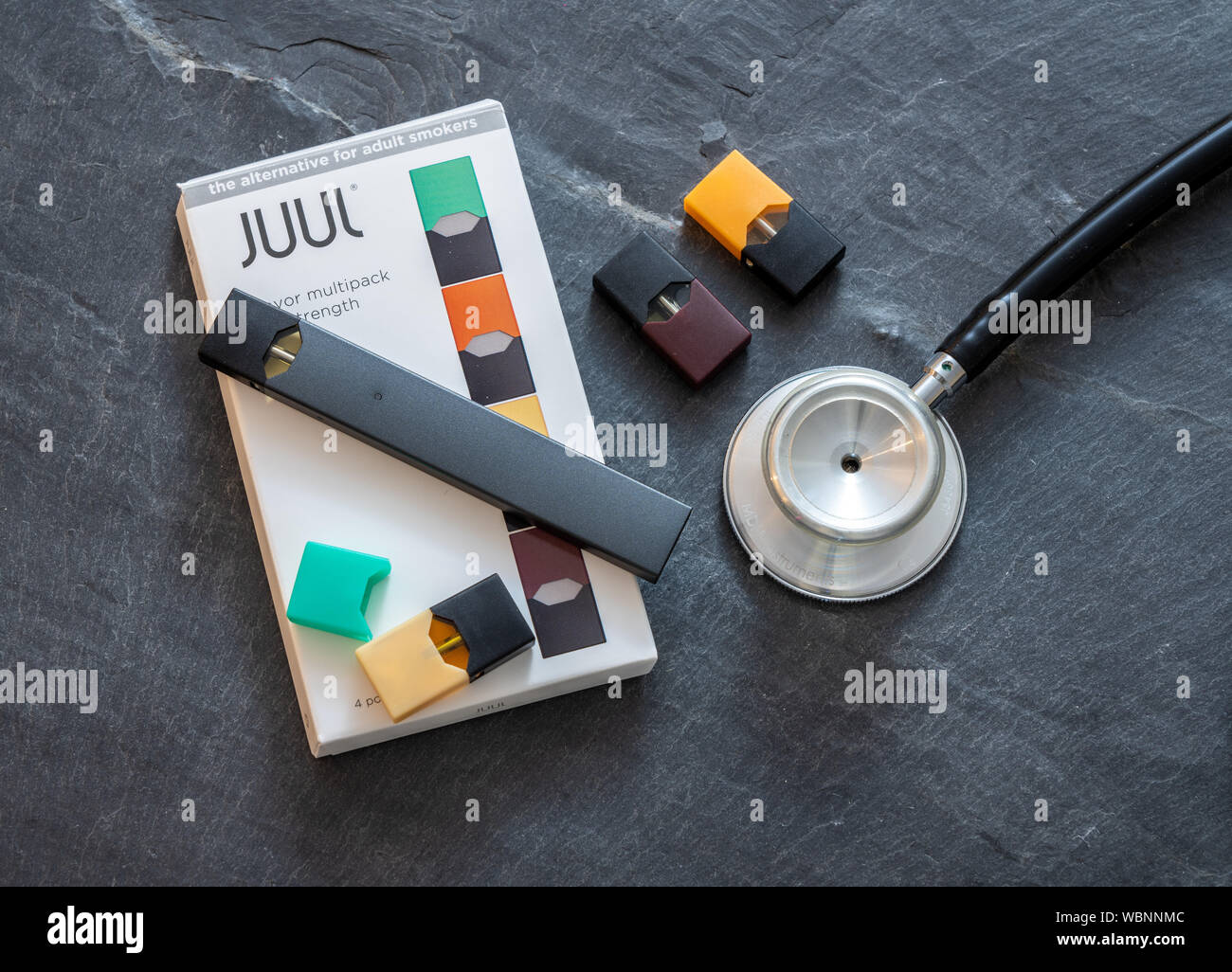 Box holding JUUL nicotine dispenser and pods with stethoscope Stock