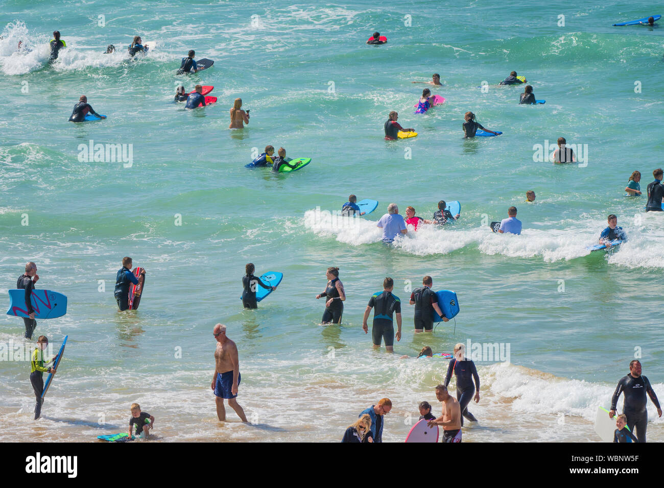 Holidaymakers on a staycation holiday enjoying themselves in the sea at Fistral in Newquay in Cornwall. Stock Photo