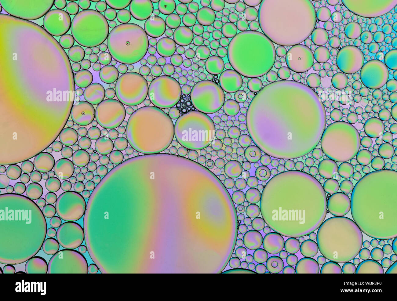 Multi-coloured bubble patterns formed by oil floating on water Stock ...