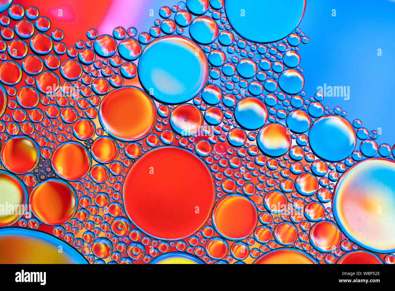 Multi-coloured bubble patterns formed by oil floating on water Stock ...